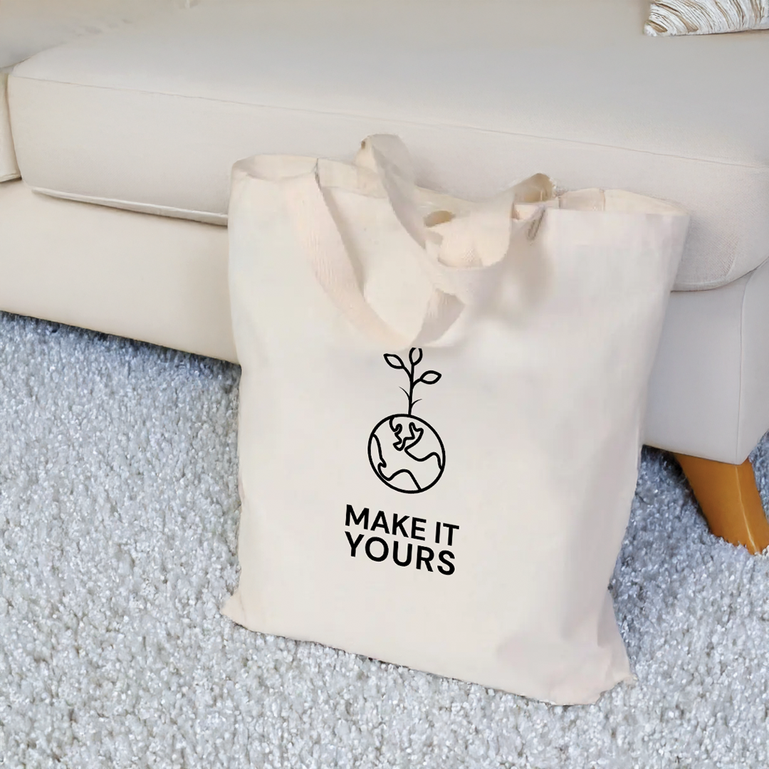 Lifestyle image of tote bag sitting on living room floor, resting against couch