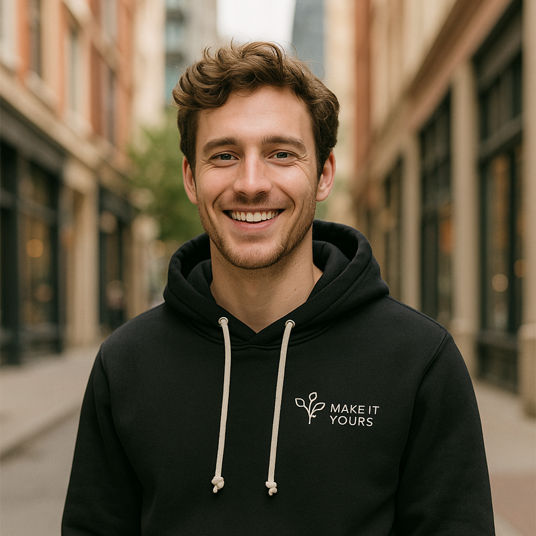 Lifestyle image of man wearing a hoodie, smiling in urban setting Lifestyle image of man wearing a hoodie, smiling in urban setting